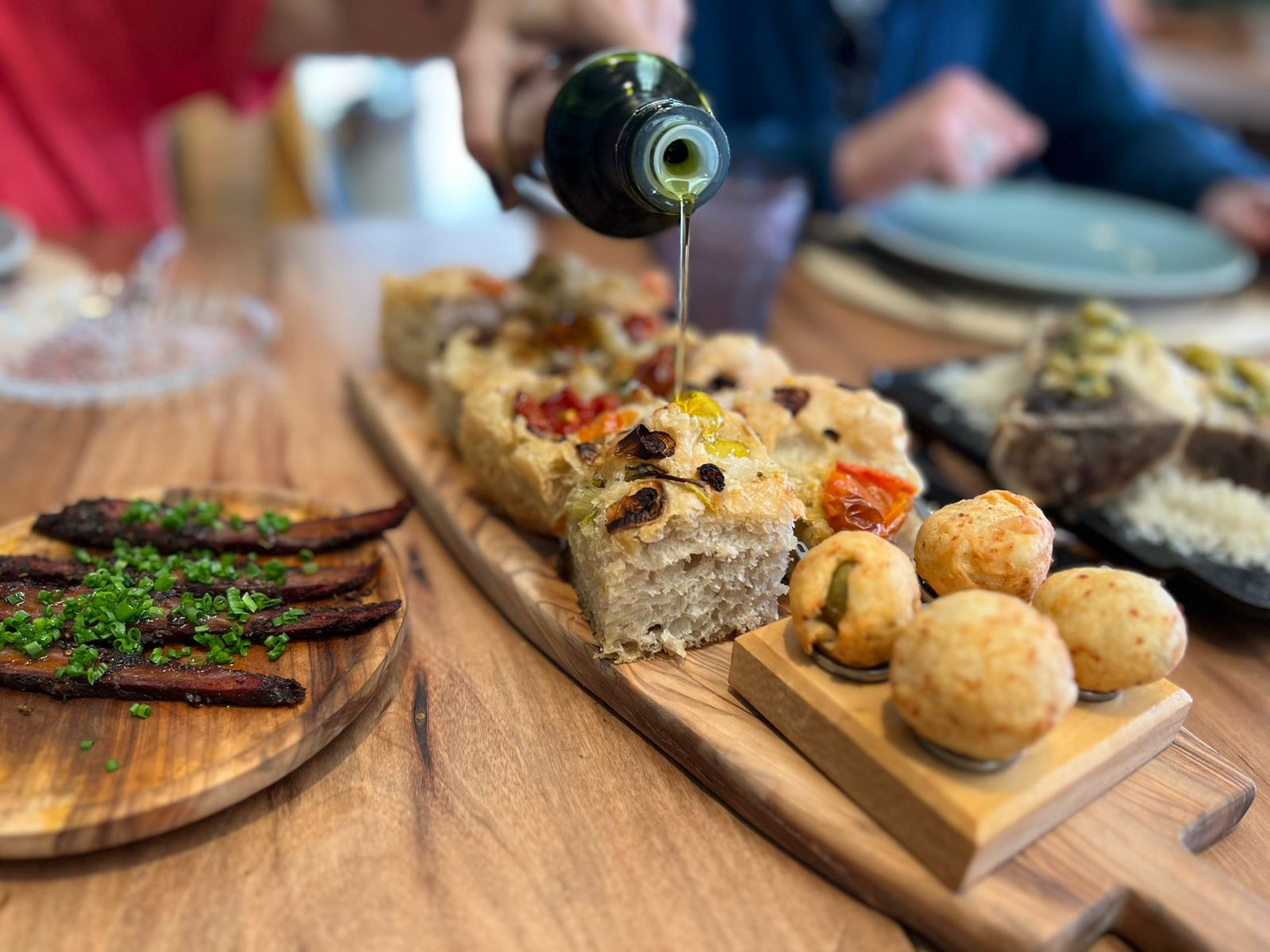 Aceite de oliva sobre pancitos y bocados para compartir
